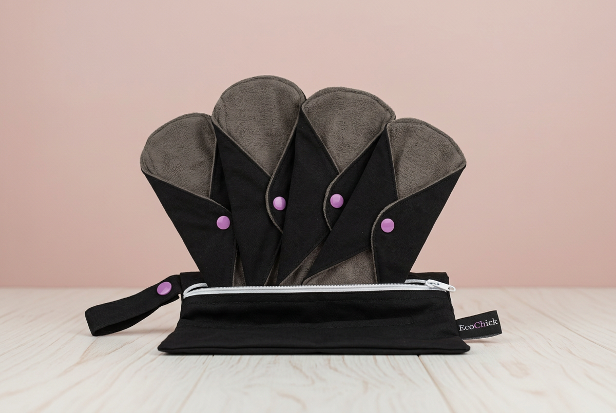Black reusable pads and matching pouch in the blush and pale wood scene