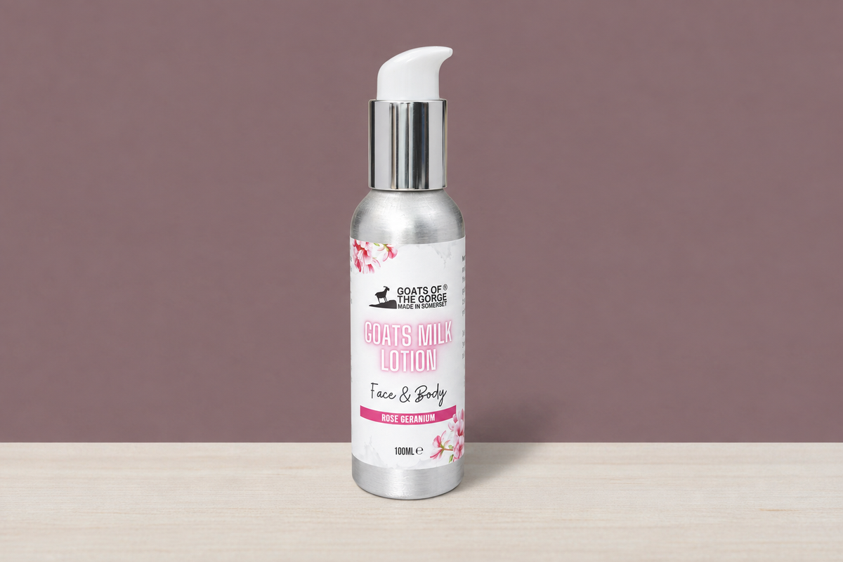 Rose Geranium Goats of the Gorge lotion bottle in the mauve wall and wood table scene
