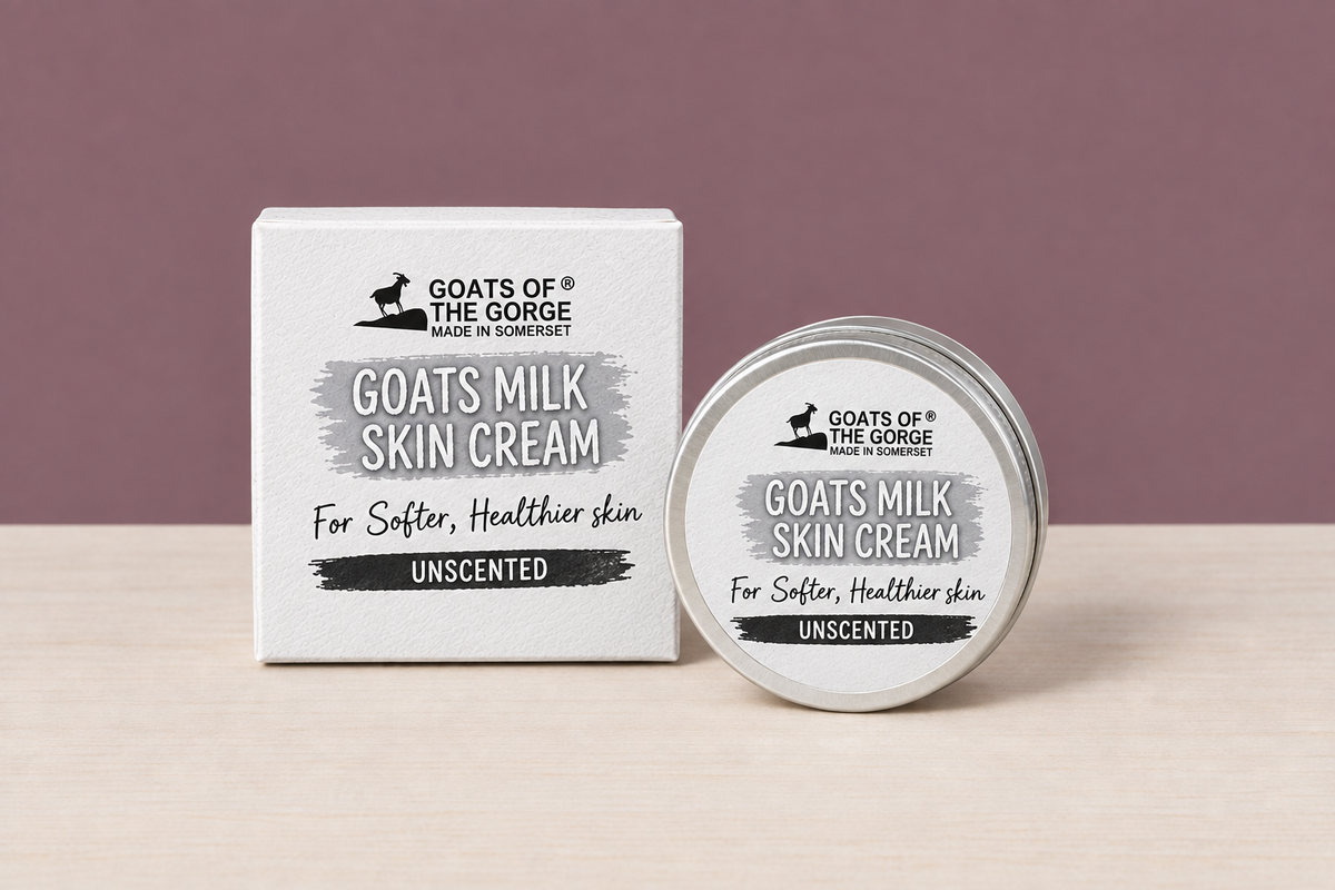 Unscented Goats Milk Skin Cream box and tin in the mauve wall and wood table scene